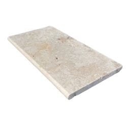 Margelle de piscine en travertin beige clair à finition adoucie. Bord arrondi (nez de marche) pour terrasse ou contour de bassin.