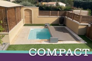 Piscine compacte "COMPACT" dans un petit jardin aménagé, avec margelles claires, gazon synthétique et volet de sécurité automatique.