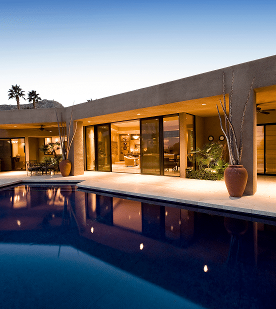 Villa Luxe Crépuscule Piscine Architecture Moderne Villa moderne au crépuscule, éclairée de l'intérieur, avec piscine sombre réfléchissant les lumières chaudes et plantes désertiques.